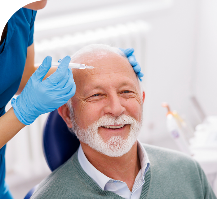 Senior man in dental chair receiving Botox injection in his forehead