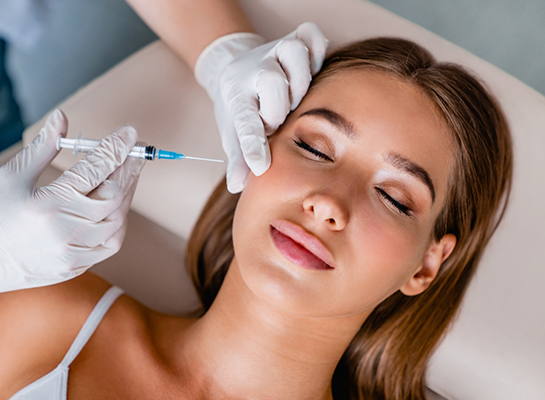 Young woman receiving Botox injection in her cheek