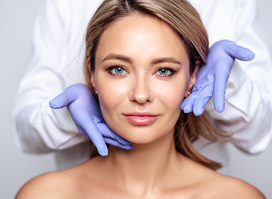 Cosmetic dentist gesturing to woman face after Botox and Xeomin treatment