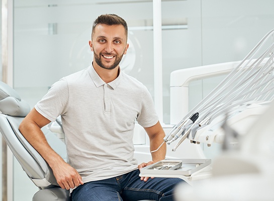 Man sitting up in dental chair and smiling