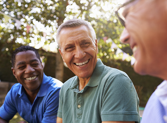 Three men laughing together outdoors