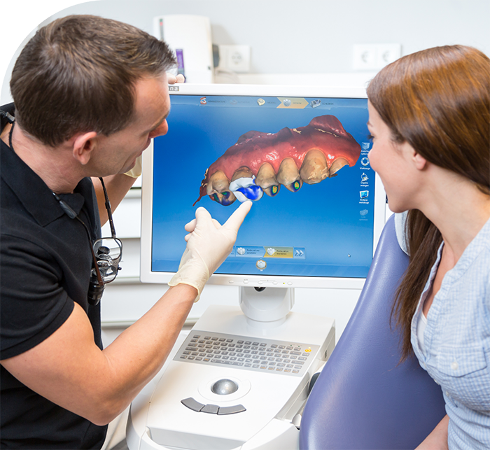 Dentist showing a patient a monitor with digital impression of teeth