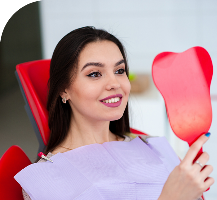 Dental patient admiring her smile after facial aesthetic services in Hanover