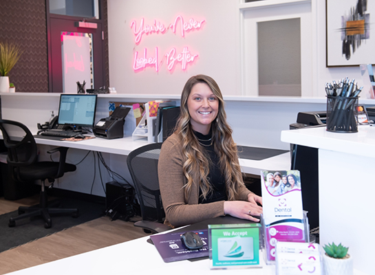 Receptionist at Dental Designs of Maryland smiling at front desk