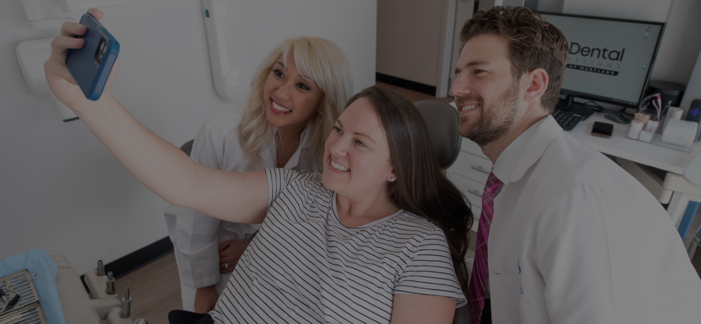 Dental patient taking selfie with Hanover dentist and assistant