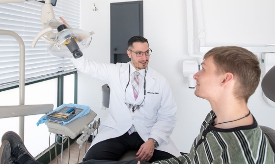 Hanover dentist moving overhead light while talking to a patient