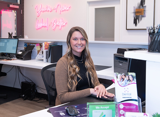 Dental office receptionist smiling at front desk