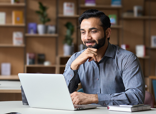 Man sitting at table in coffee shop on his laptop