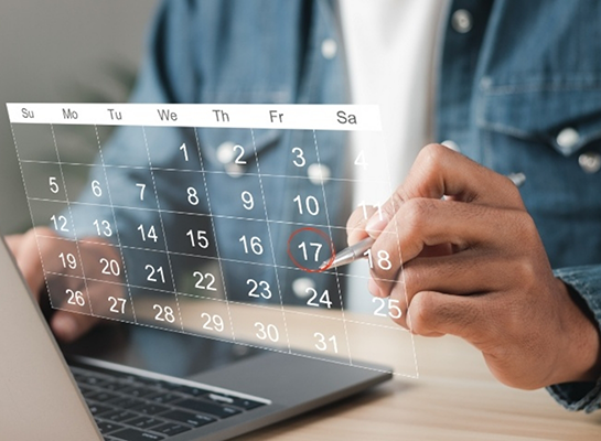 Person circling date of dental appointment on holographic calendar