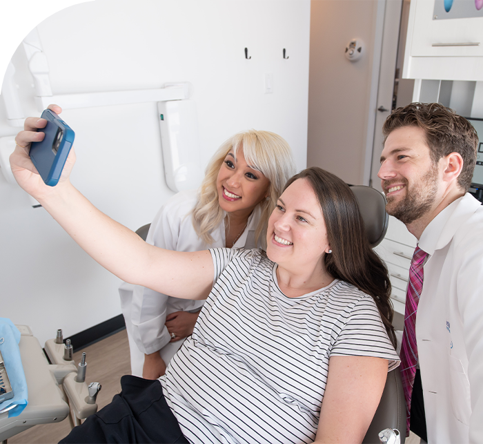 Woman taking selfie with dentist after receiving dental services in Hanover