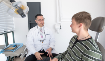 Dentist talking to young man in the dental chair