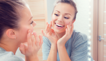 Young woman looking at her smile in mirror