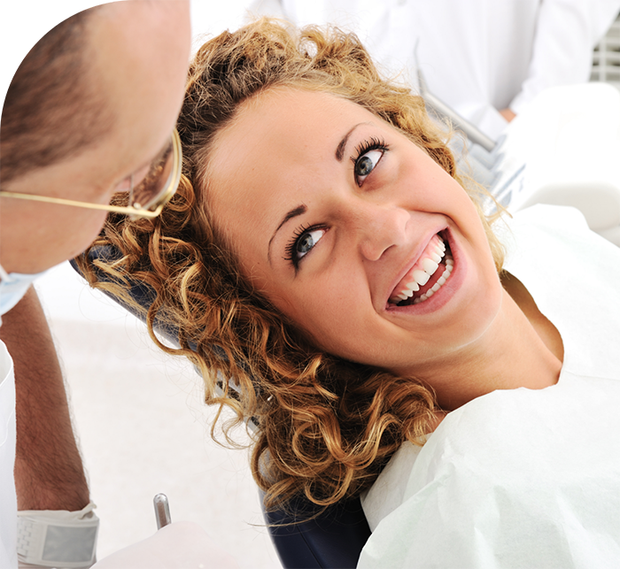 Woman grinning at her dentist after root canal treatment in Hanover